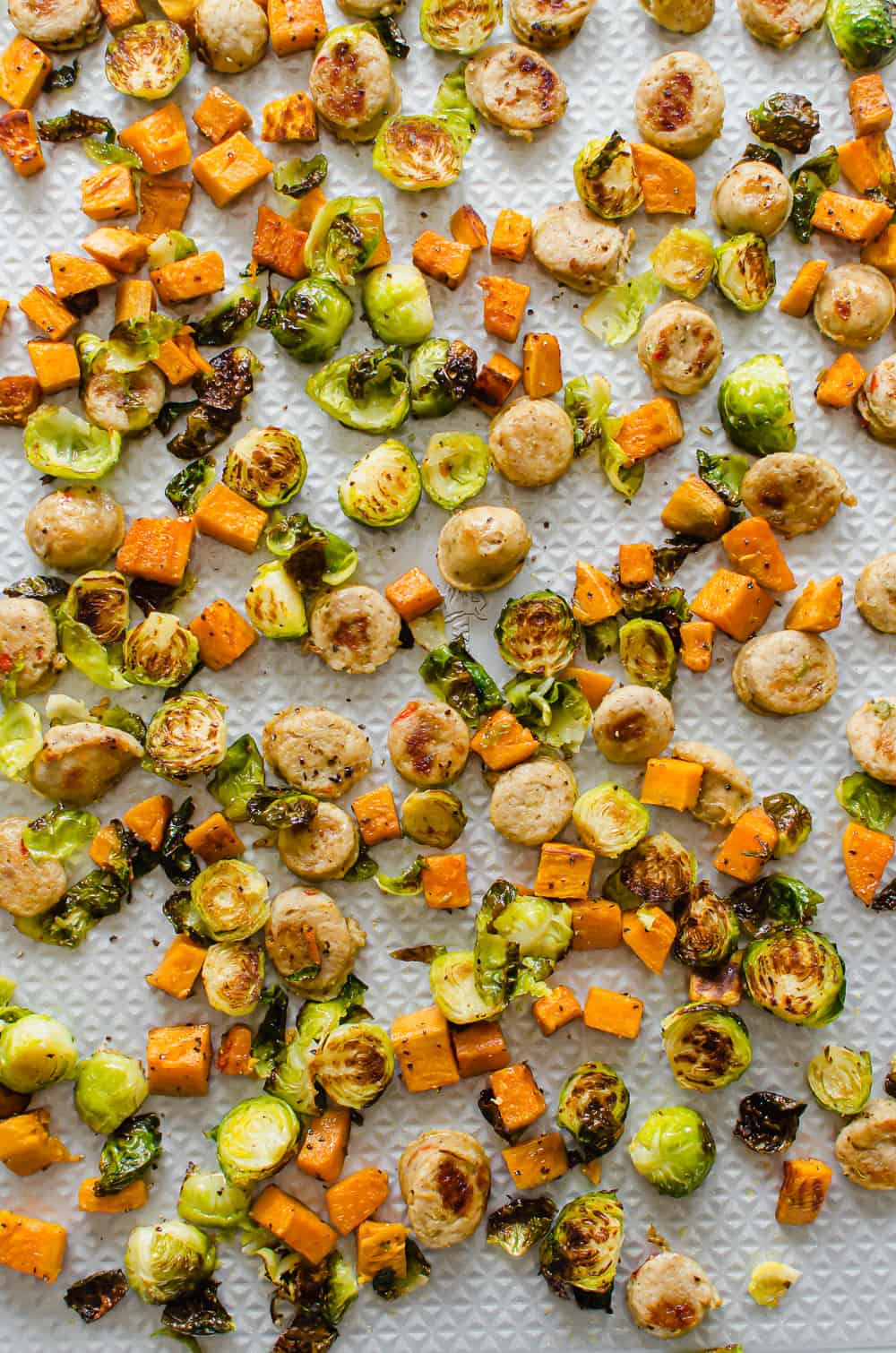 roasted sausage and veggies on a sheet pan after coming out of the oven.