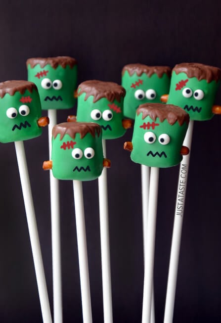 Marshmallows on sticks covered with green-colored chocolate and decorations to make them look like Frankensteins.