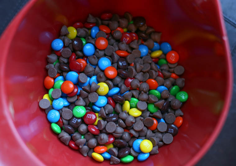 m&ms and chocolate chips in a red bowl