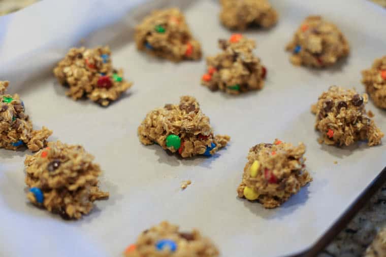 Monster cookie cookie dough on a parchment lined baking sheet