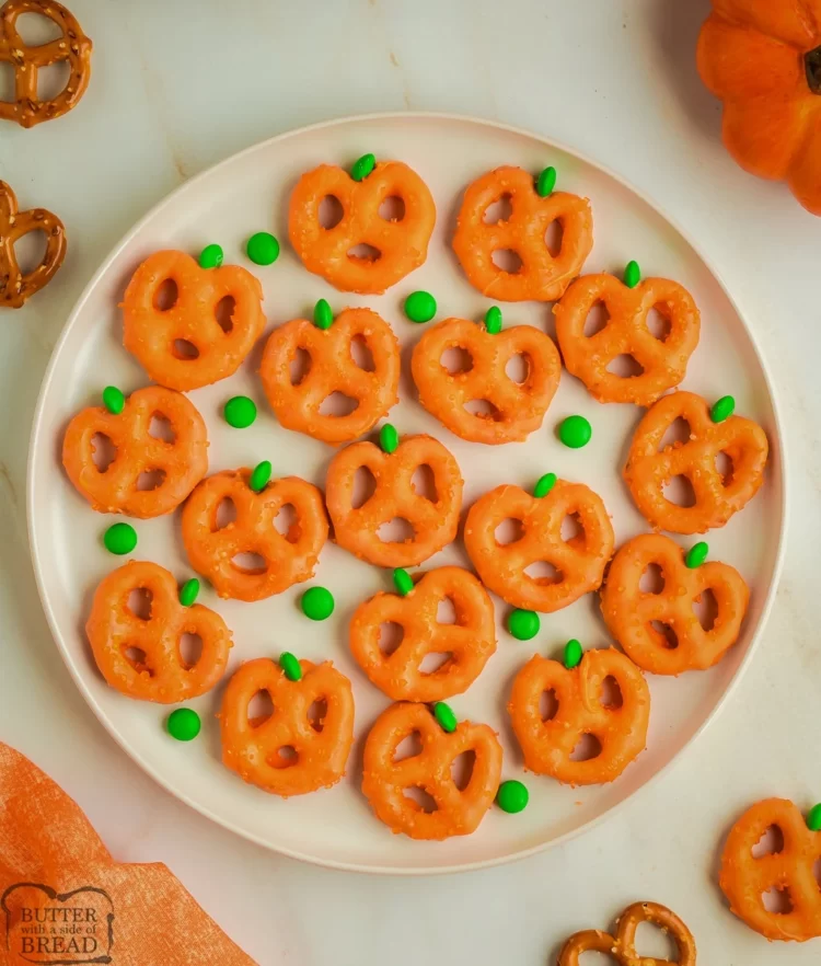 Orange chocolate covered pretzels made to look like pumpkins with mini green m&m stems.