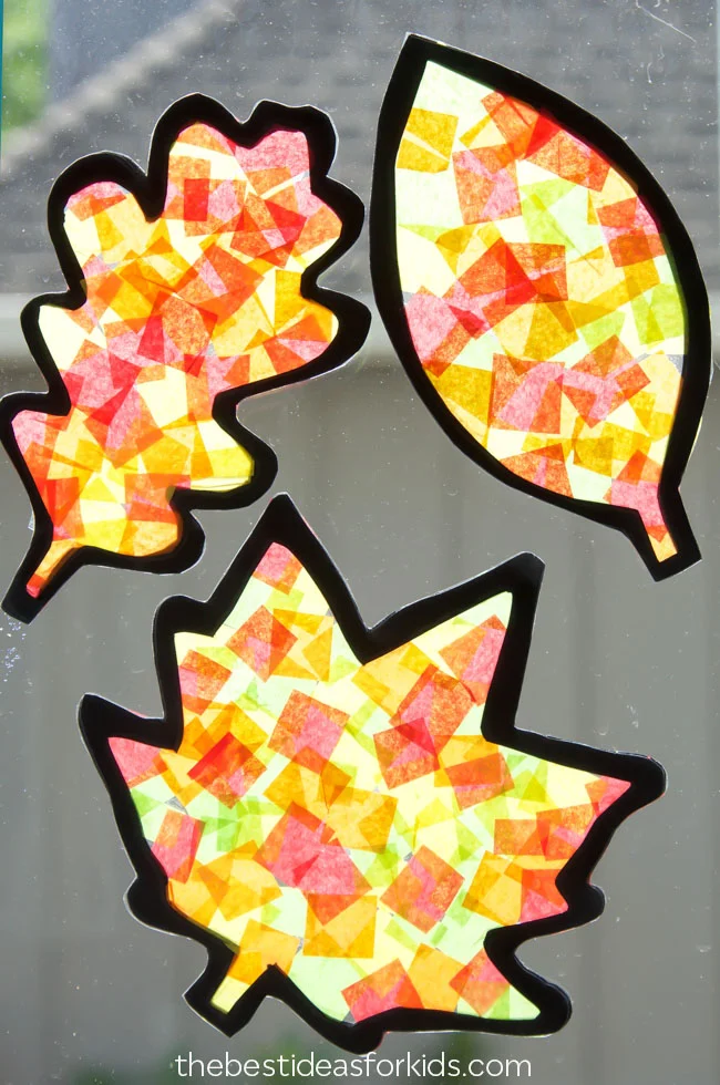 Fall-colored tissue paper pieces glued to leaf shapes to make suncatchers.