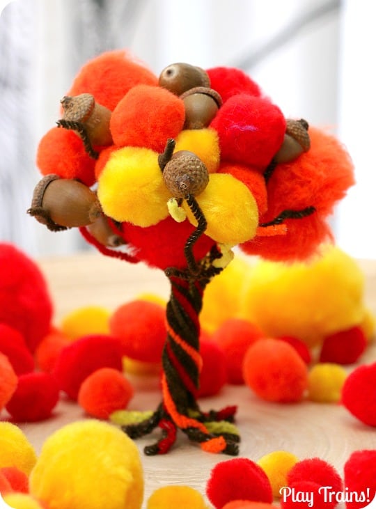 Fall tree made of green, orange and brown pom poms, pipe cleaners, and acorns.