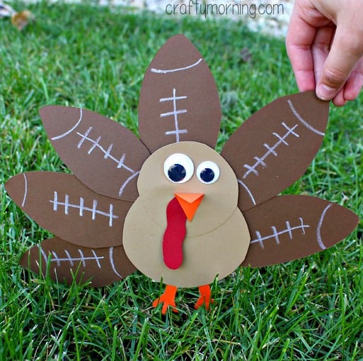 A construction paper turkey with the feathers made out of brown construction paper decorated to look like footballs.