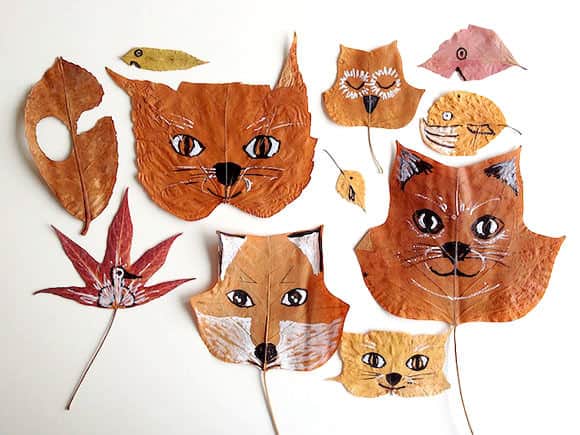 Different shaped and colored dried leaves with faces painted on them to look like animals.