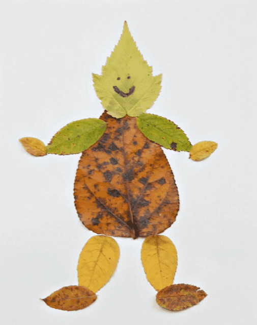Different sized leaves glued on construction paper in the shape of a person.