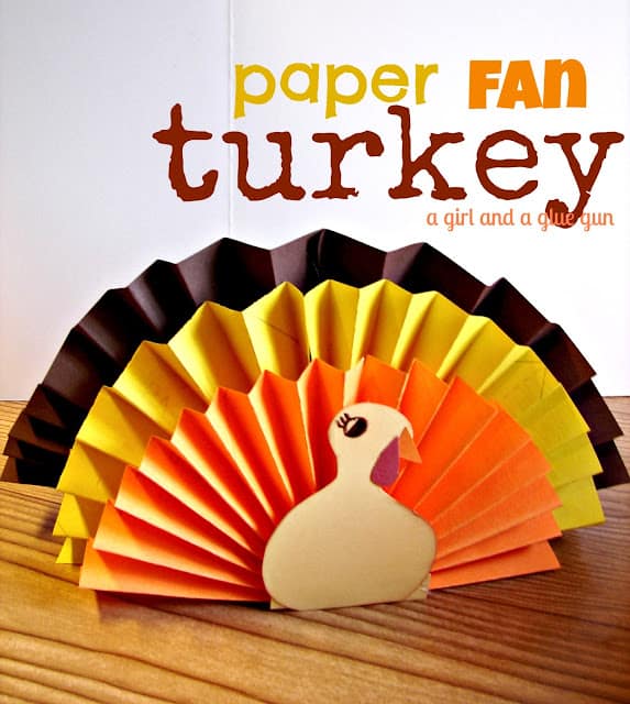A large brown construction paper accordian fan, with a medium-size yellow fan, and a small orange one layered as the feathers of a turkey.