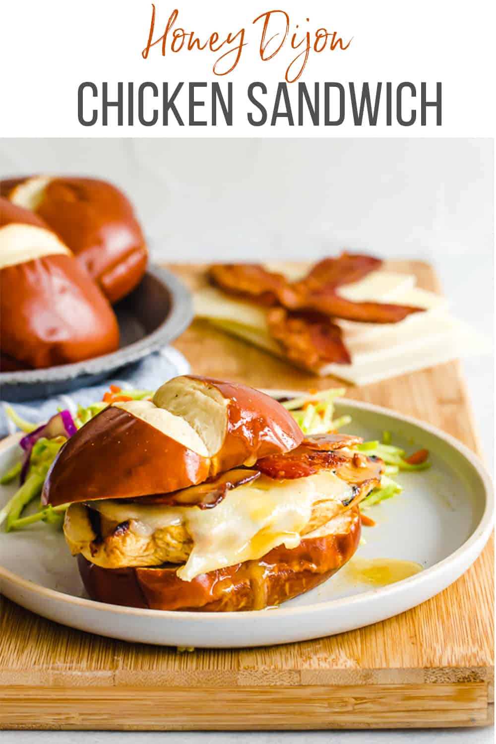 Chicken sandwich on a pretzel bun on a plate.