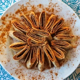 Cinnamon tortilla roll-ups on a plate.