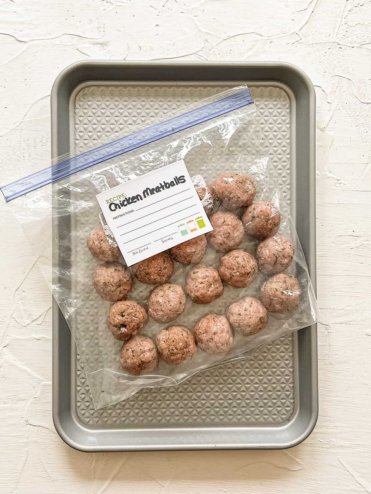 Frozen chicken meatballs in a freezer bag.