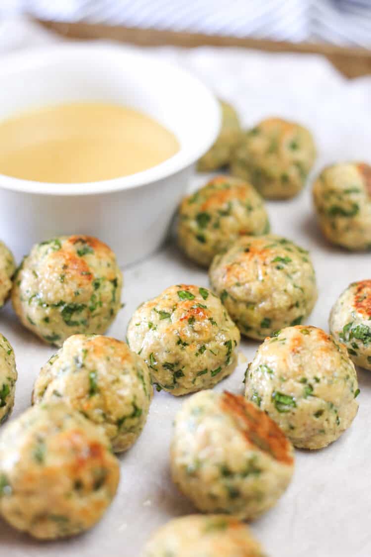 Chicken meatballs on a pan with honey mustard dipping sauce.