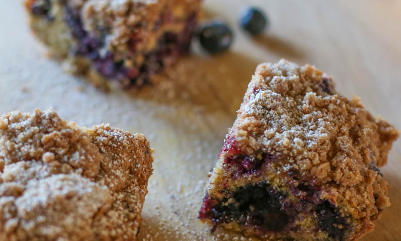Blueberry Crumble Breakfast Cake cut up on a wooden cutting board