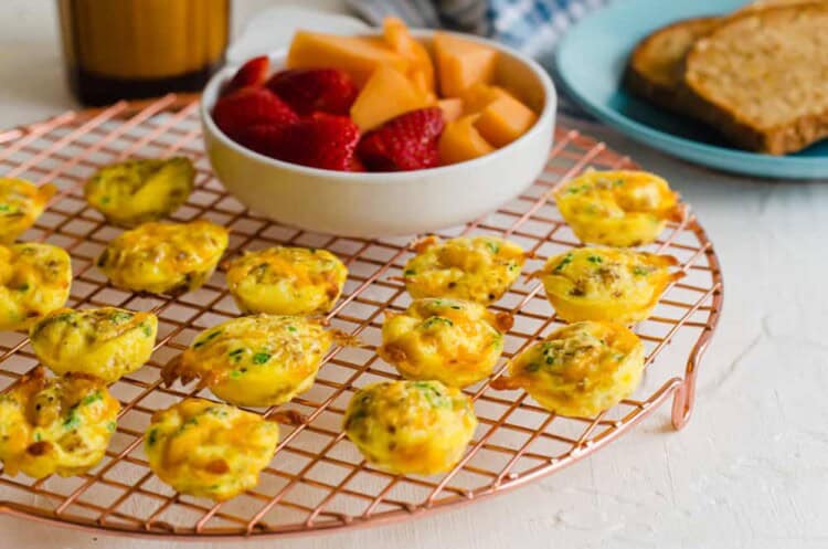 Cheddar chive egg bites on a cooling rack.