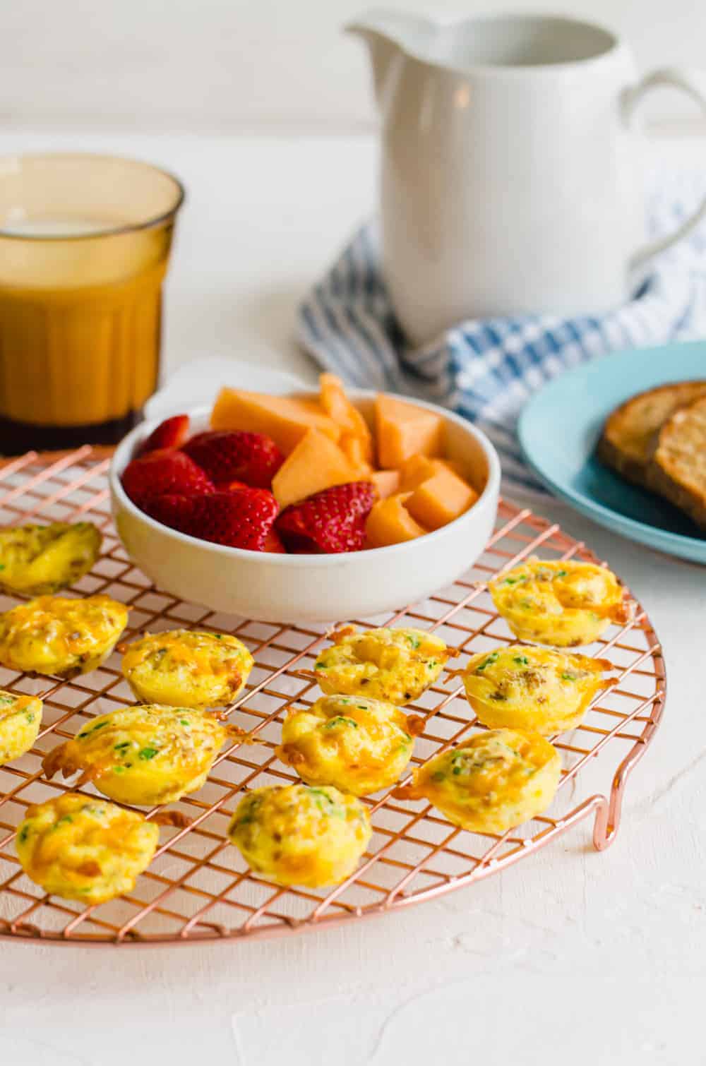 Mini cheddar chive egg bites on a baking rack.