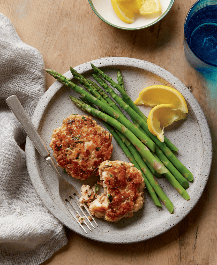 Freezer friendly salmon burgers on a plate with asparagus
