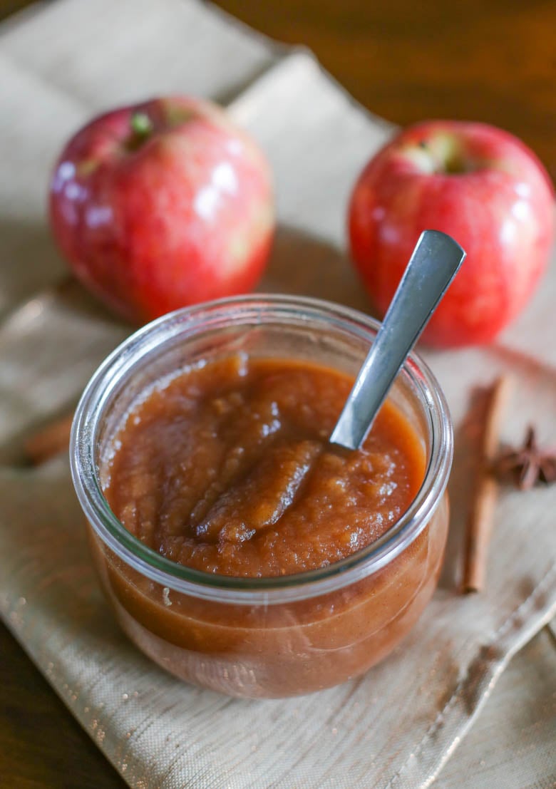 Homemade apple butter in a small jar with a spoon.