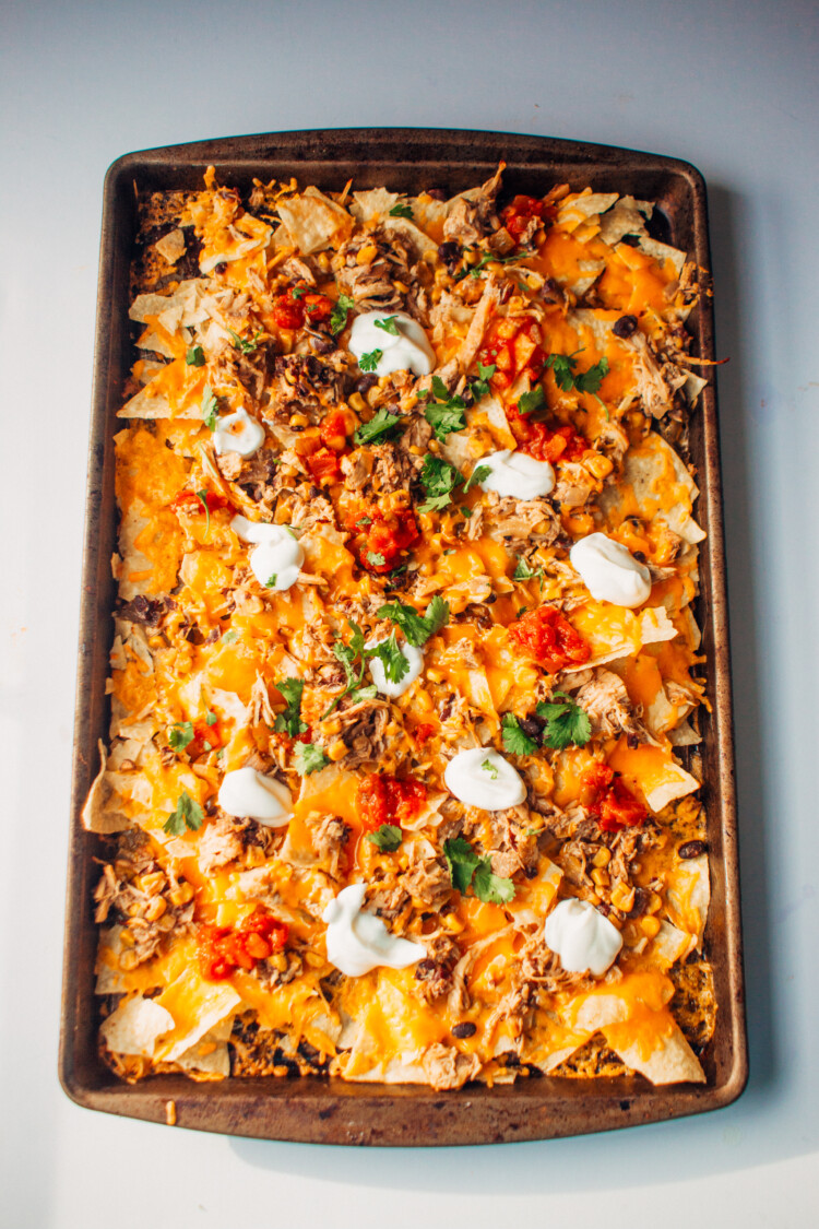 Chicken nachos on a baking sheet just out of the oven.
