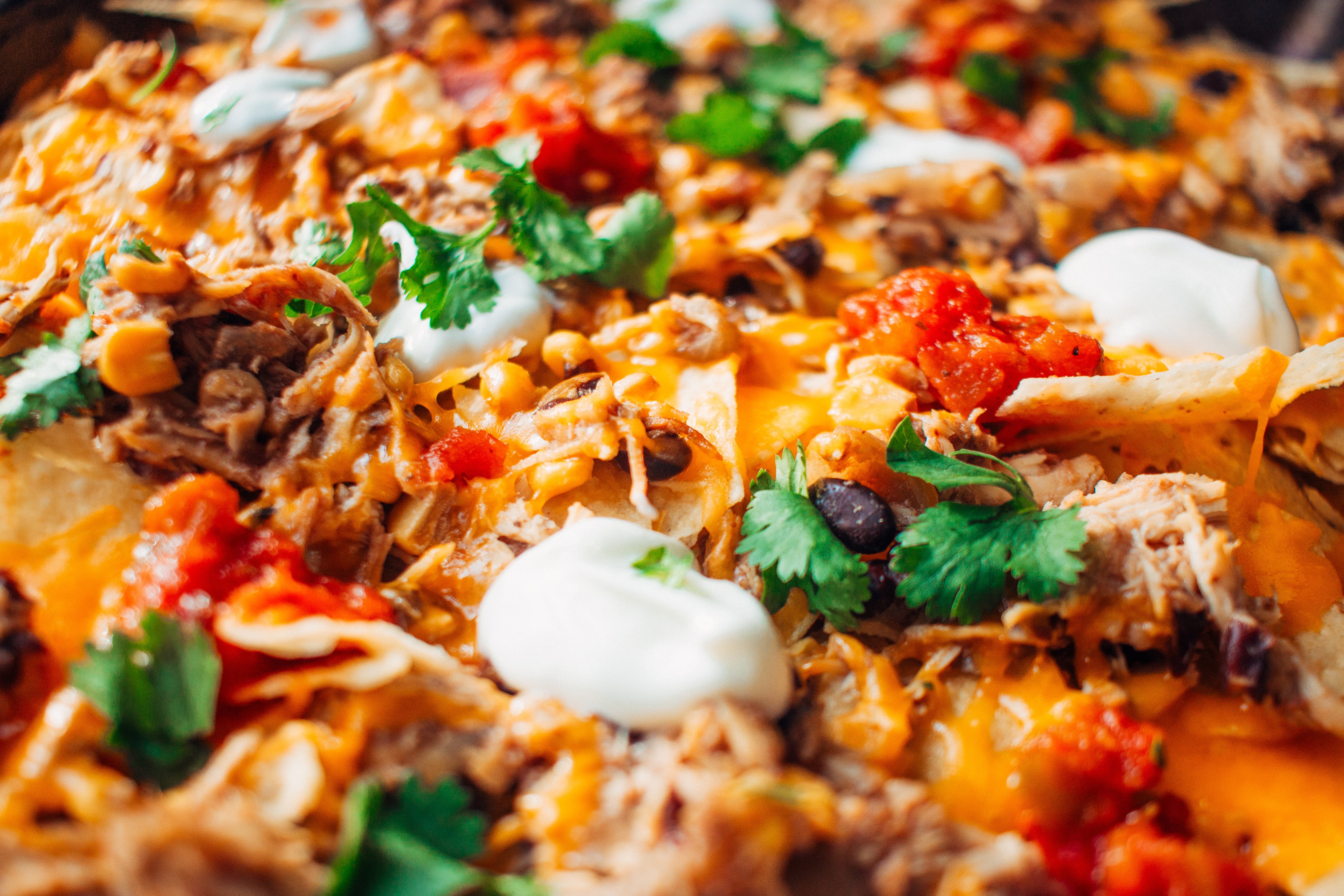 Instant pot chicken nachos with toppings ready to eat.