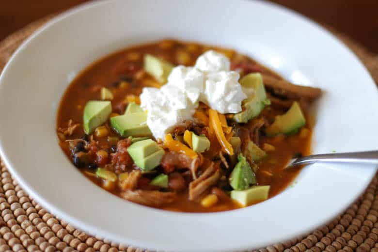 chicken fiesta soup in a white bowl with spoon