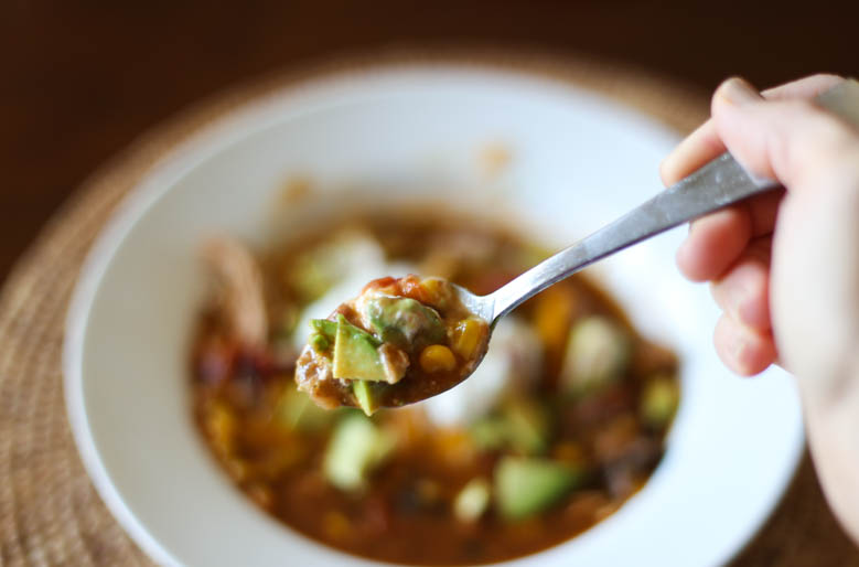 A spoon scooping up a bite of chicken taco soup