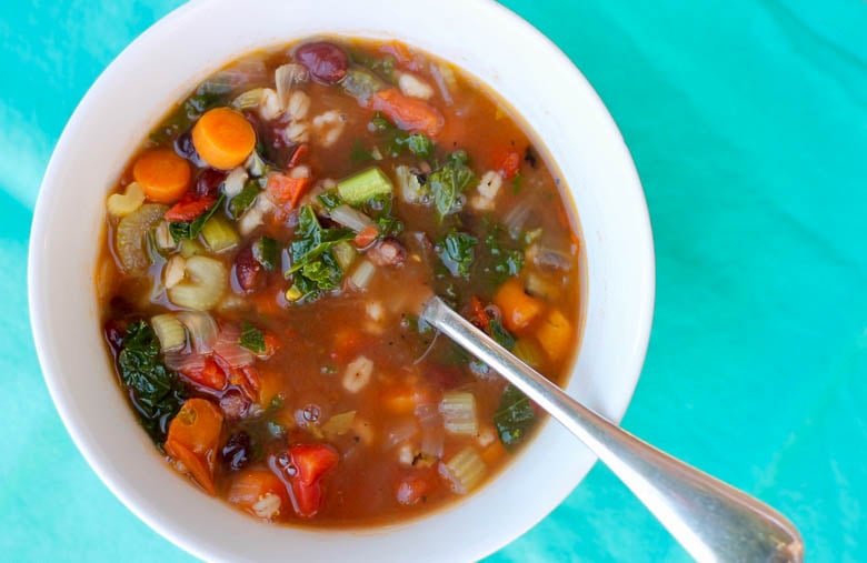 A white bowl with spoon filled with Instant Pot Vegetable Soup
