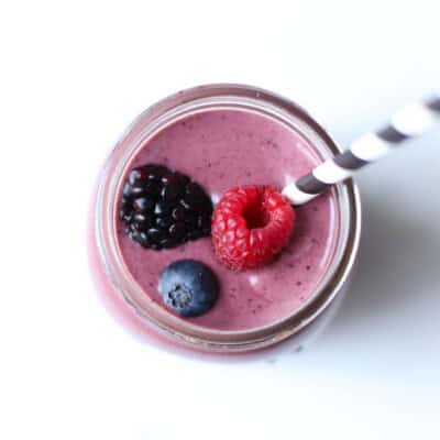 berry smoothie in mason jar with straw