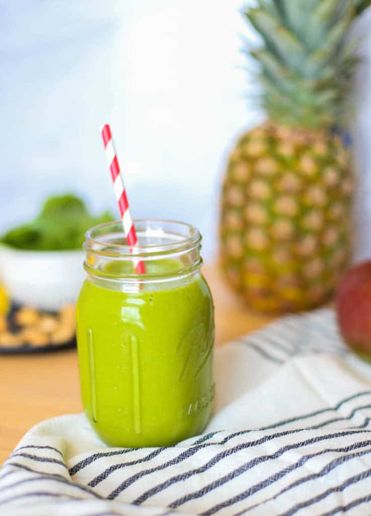 pineapple, mango, spinach, cashews on cutting board