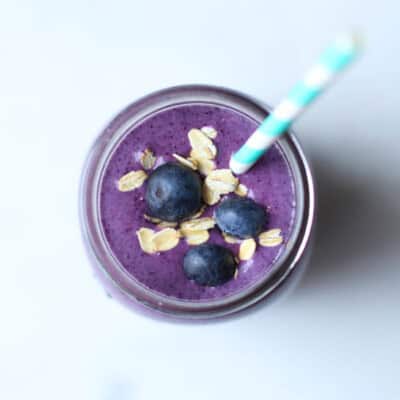 blueberry smoothie in mason jar with straw