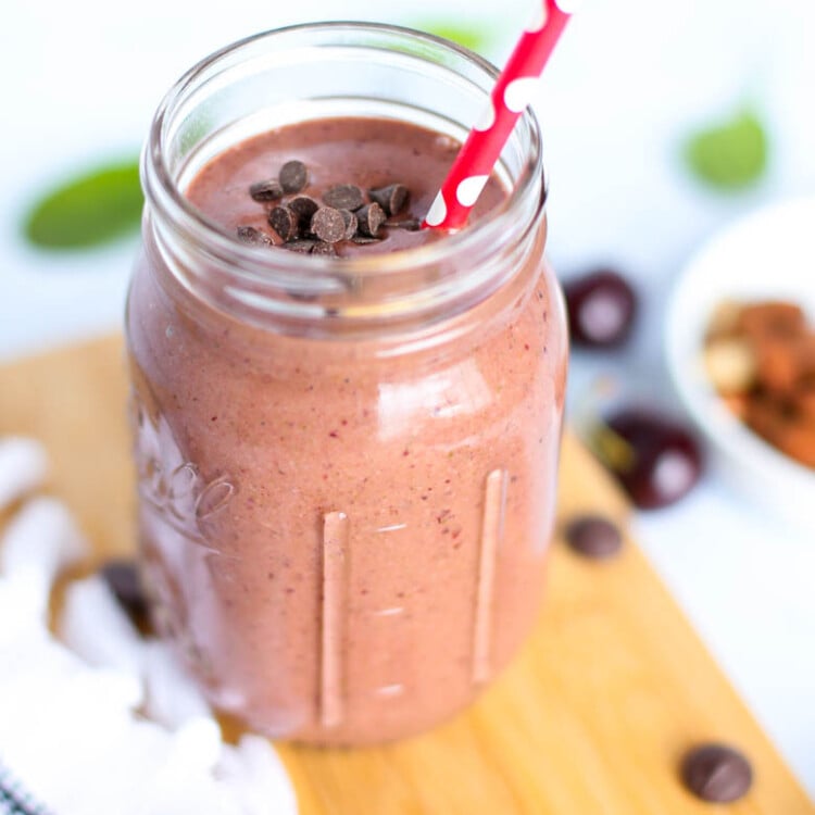 Chocolate covered cherry smoothie in mason jar with straw.