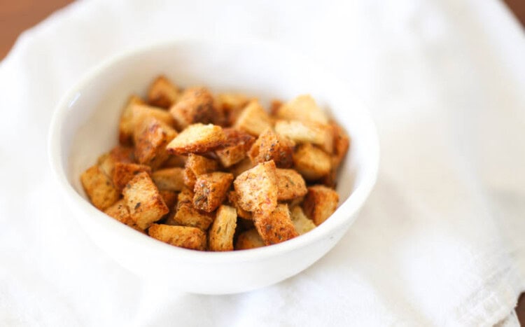 Homemade croutons in a white bowl.