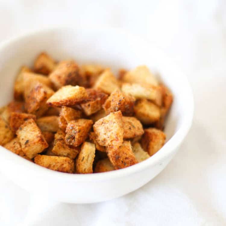 Homemade croutons in a white bowl.