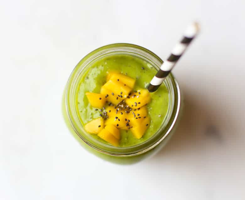 green smoothie with mango and chia in mason jar with straw