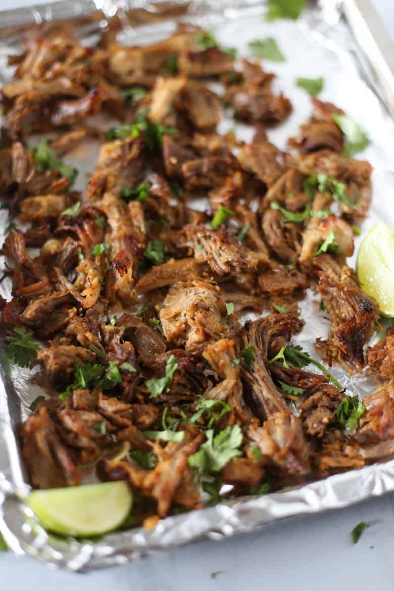 Pork shoulder shredded and broiled on a foil lined baking sheet for Carnitas.