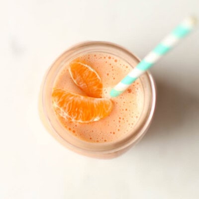 Orange smoothie in mason jar with straw