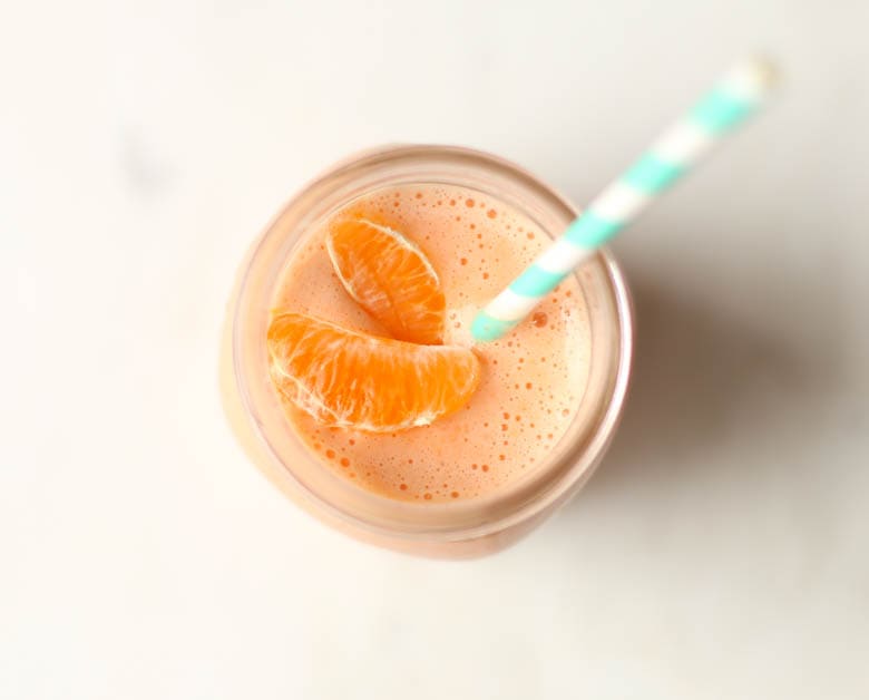 Orange smoothie in mason jar with straw