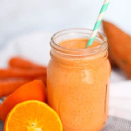 Orange smoothie in mason jar with straw
