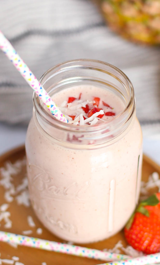 Pina colada smoothie in a mason jar with colorful straw