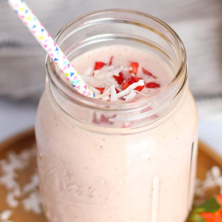 Strawberry smoothie in mason jar with straw.