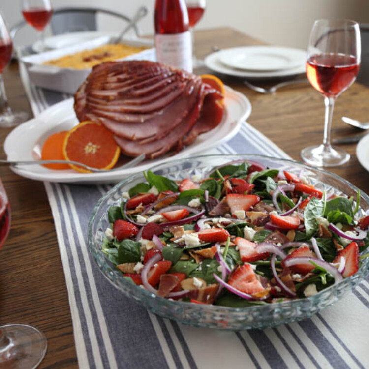 Easter brunch on table with salad, ham, potato casserole, and cherry moscato wine