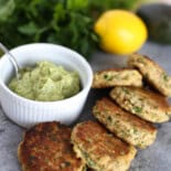 Mini wild salmon patties with lemony avocado sauce in a bowl.