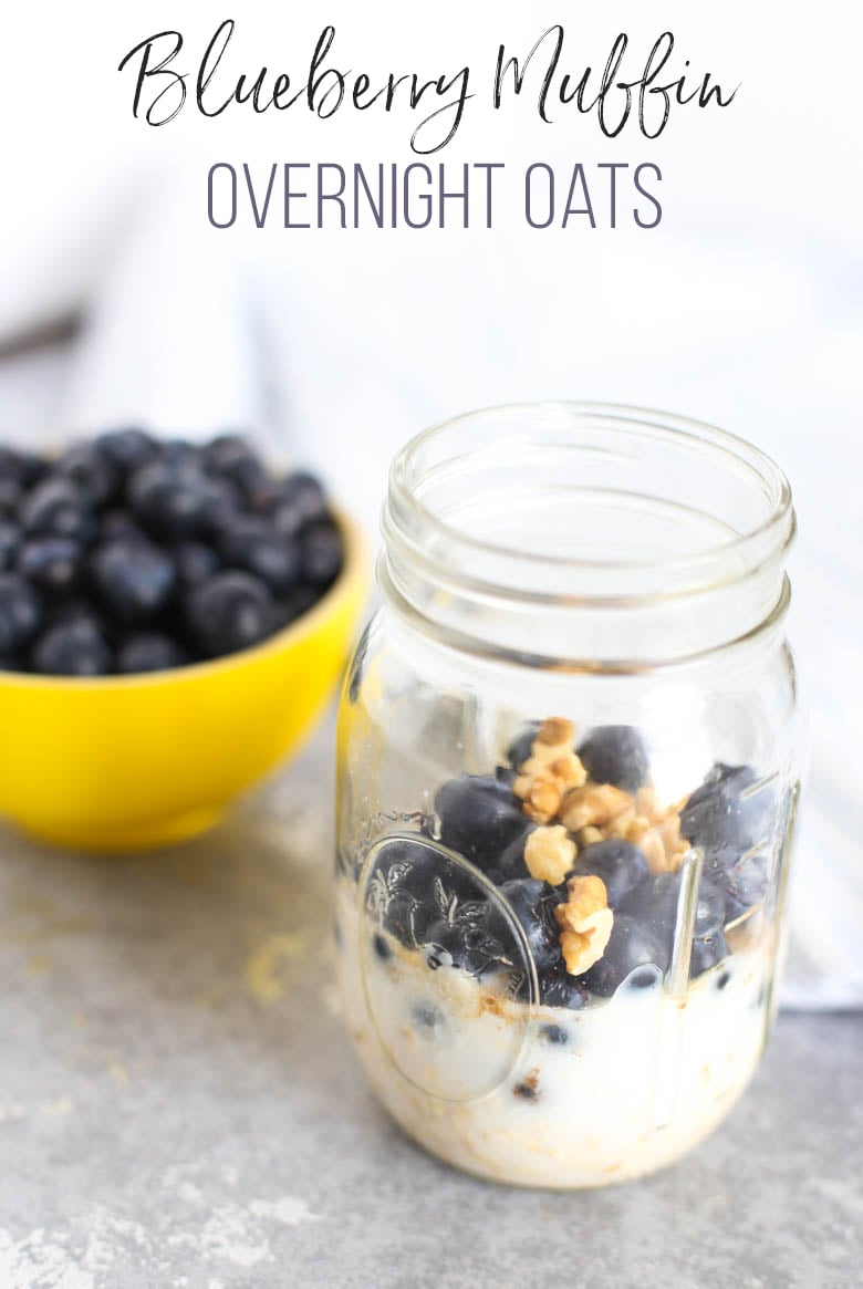 Blueberry Overnight Oats ingredients layered in a mason jar with a yellow bowl of blueberries in the background.