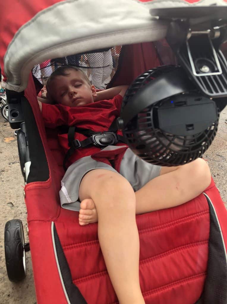 Sleeping boy with clip on fan on stroller