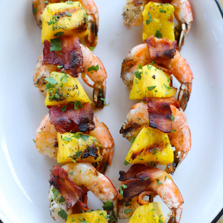 bacon-wrapped shrimp kabobs on white platter