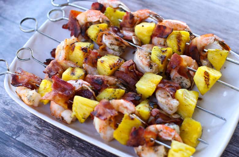 Bacon-Wrapped Shrimp and Pineapple Kabobs on a white platter.