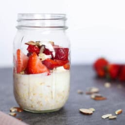 Strawberry shortcake overnight oats in a mason jar on the counter.