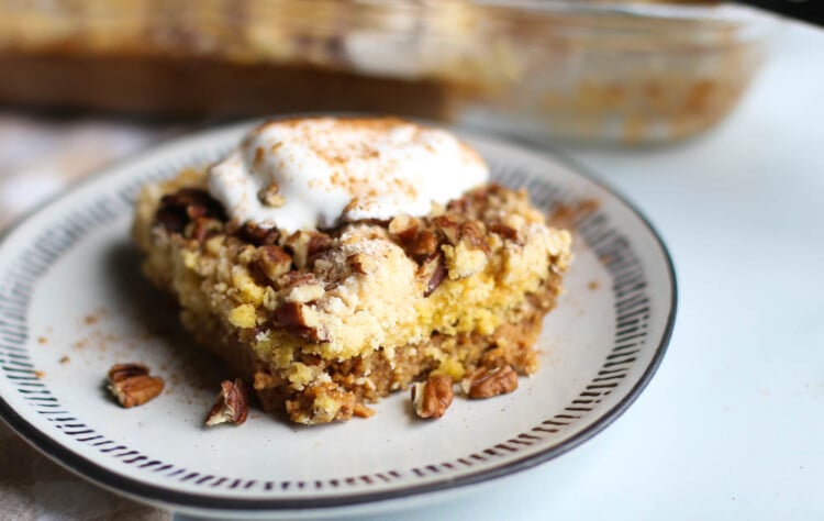 Slice of pumpkin dump cake with whipped topping.