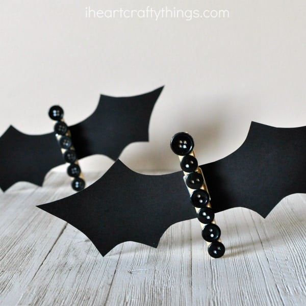 Clothespin Button Bats craft for kids made by gluing black buttons to a clothespin and black construction paper cut in the shape of a bat wings.