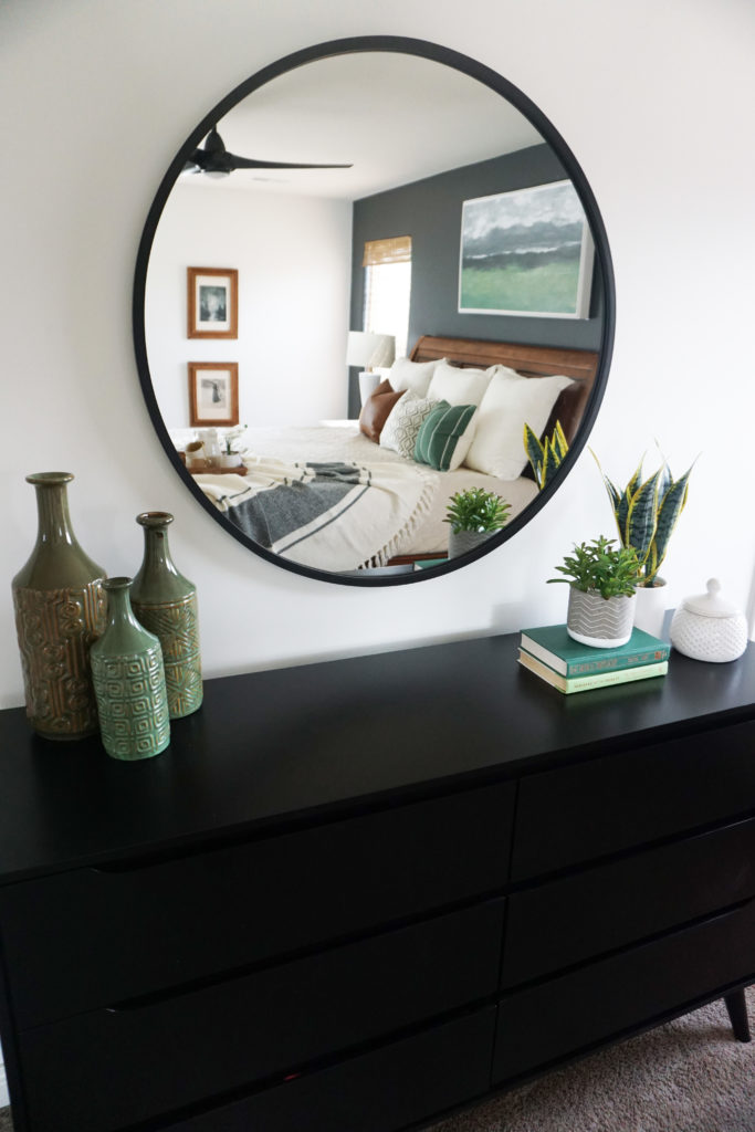 Black dresser with circle mirror