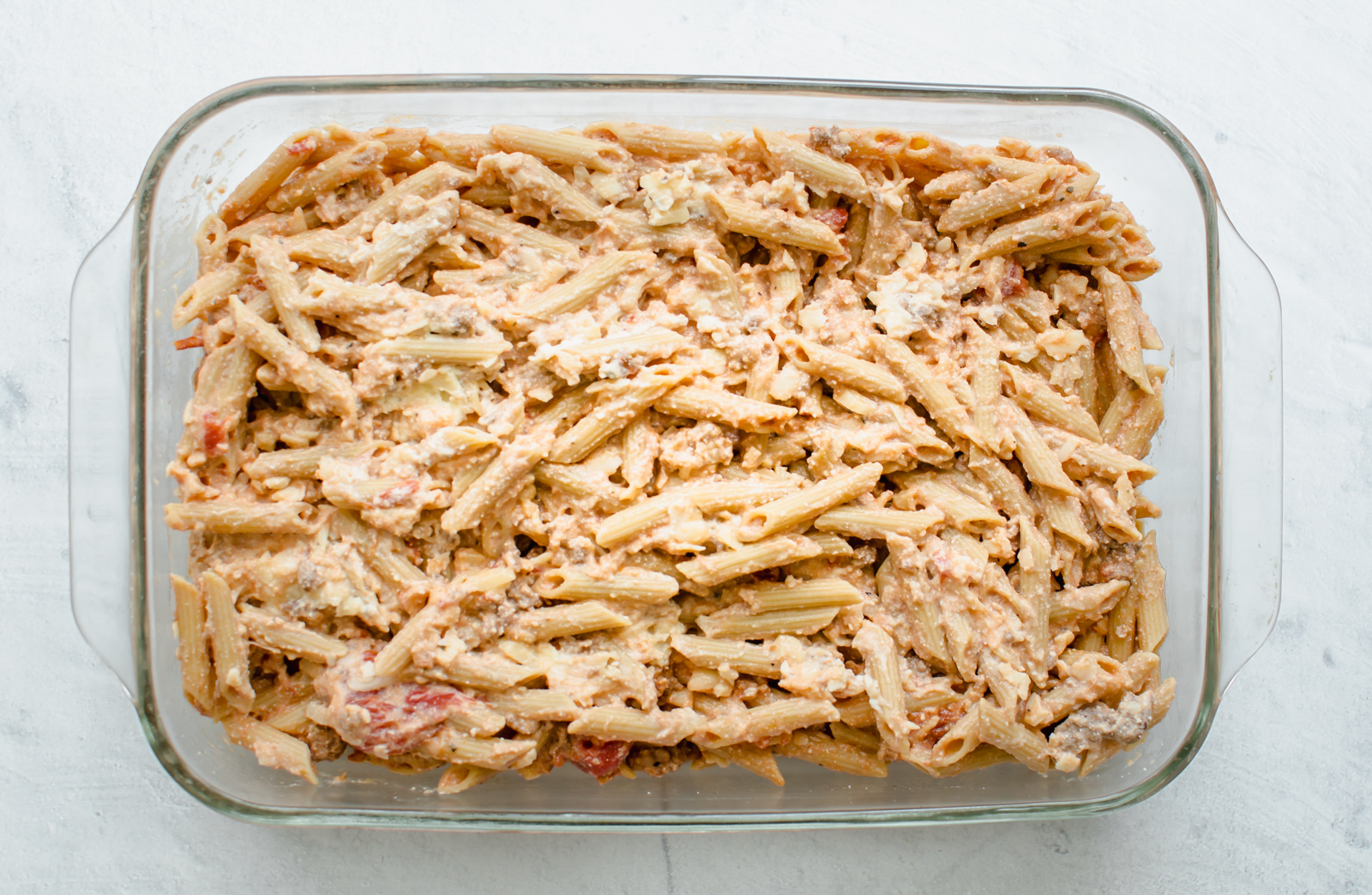 baked penne pasta in a glass dish. 
