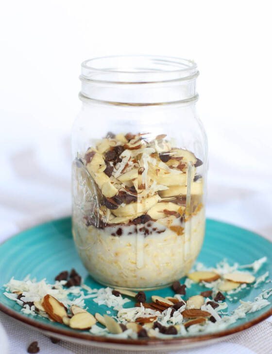 Almond joy overnight oats in a mason jar sitting on a turquoise plate.